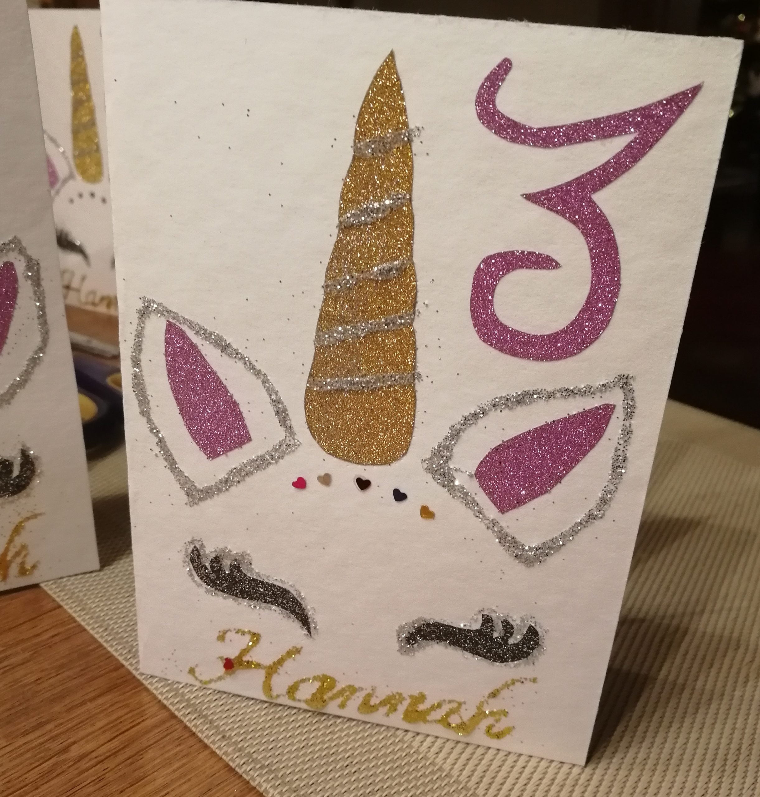 Eine handgefertigte Einhorn-Einladungskarte mit einem funkelnden Horn, zarten Ohren und niedlichen Wimpern, die perfekt für einen magischen Geburtstag sind.