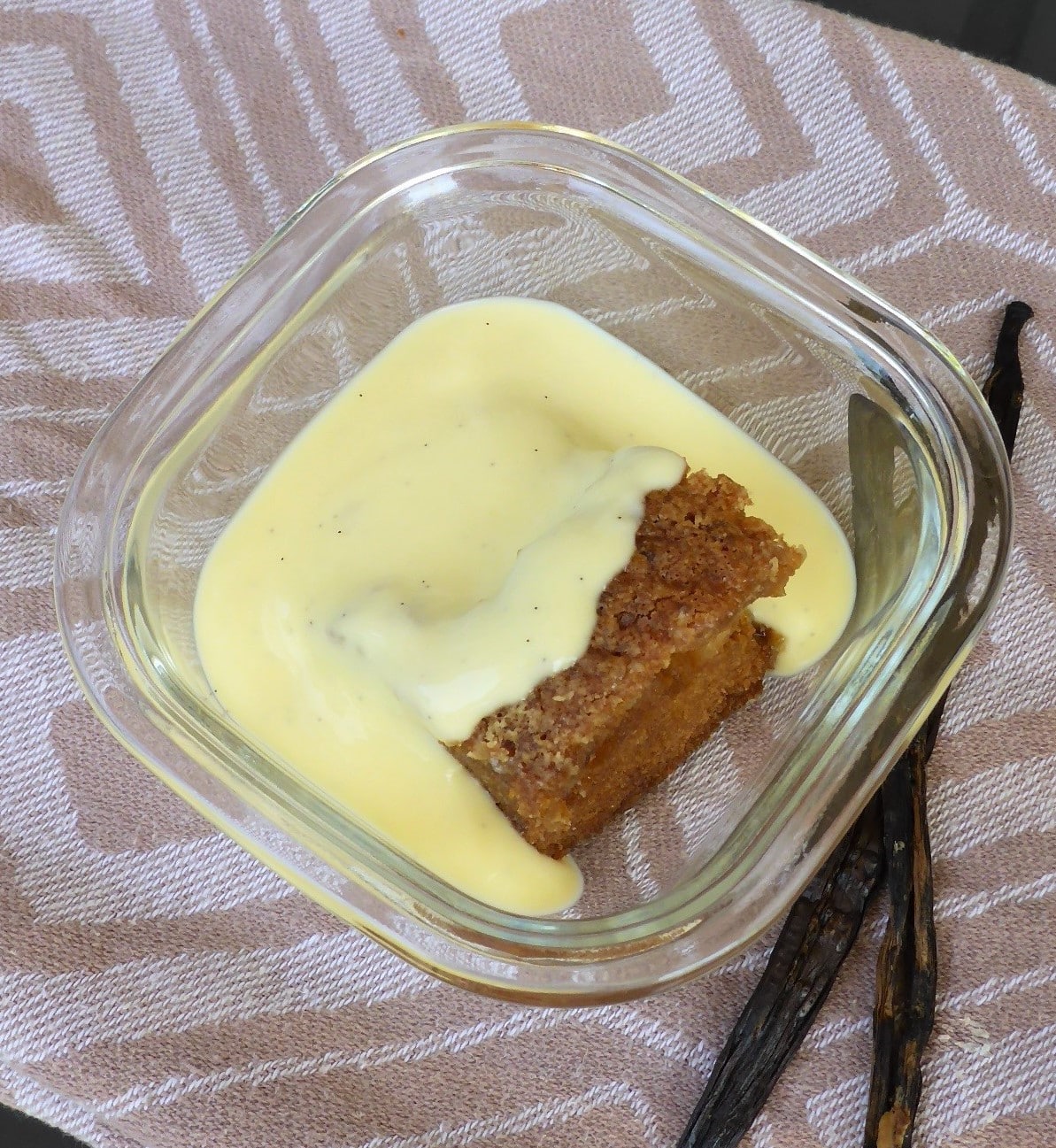 Ein Bild von einem süßen Dessert: Malva Pudding, serviert mit köstlicher Vanillesoße.