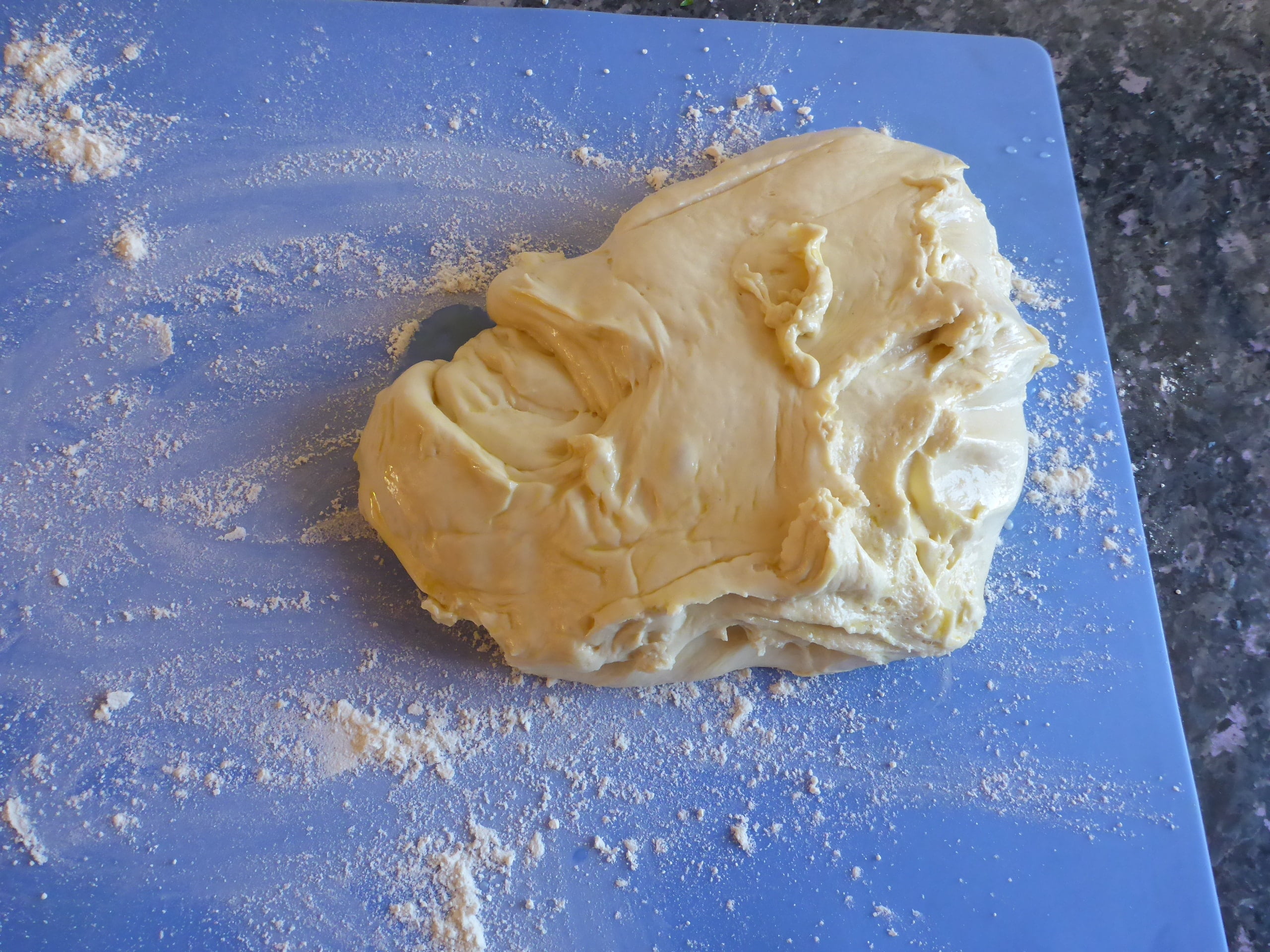 Yeast dough transferred on a cutting board after the first rise.