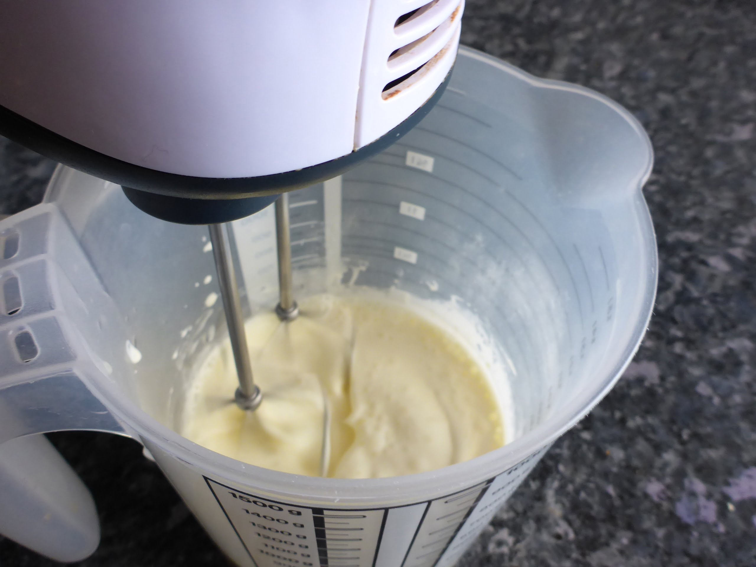 Schritt-für-Schritt-Anleitung für die Zubereitung von Vanilleeis ohne Eier: Die Schlagsahne wird steif geschlagen, um Volumen und eine cremige Textur zu erzeugen. 