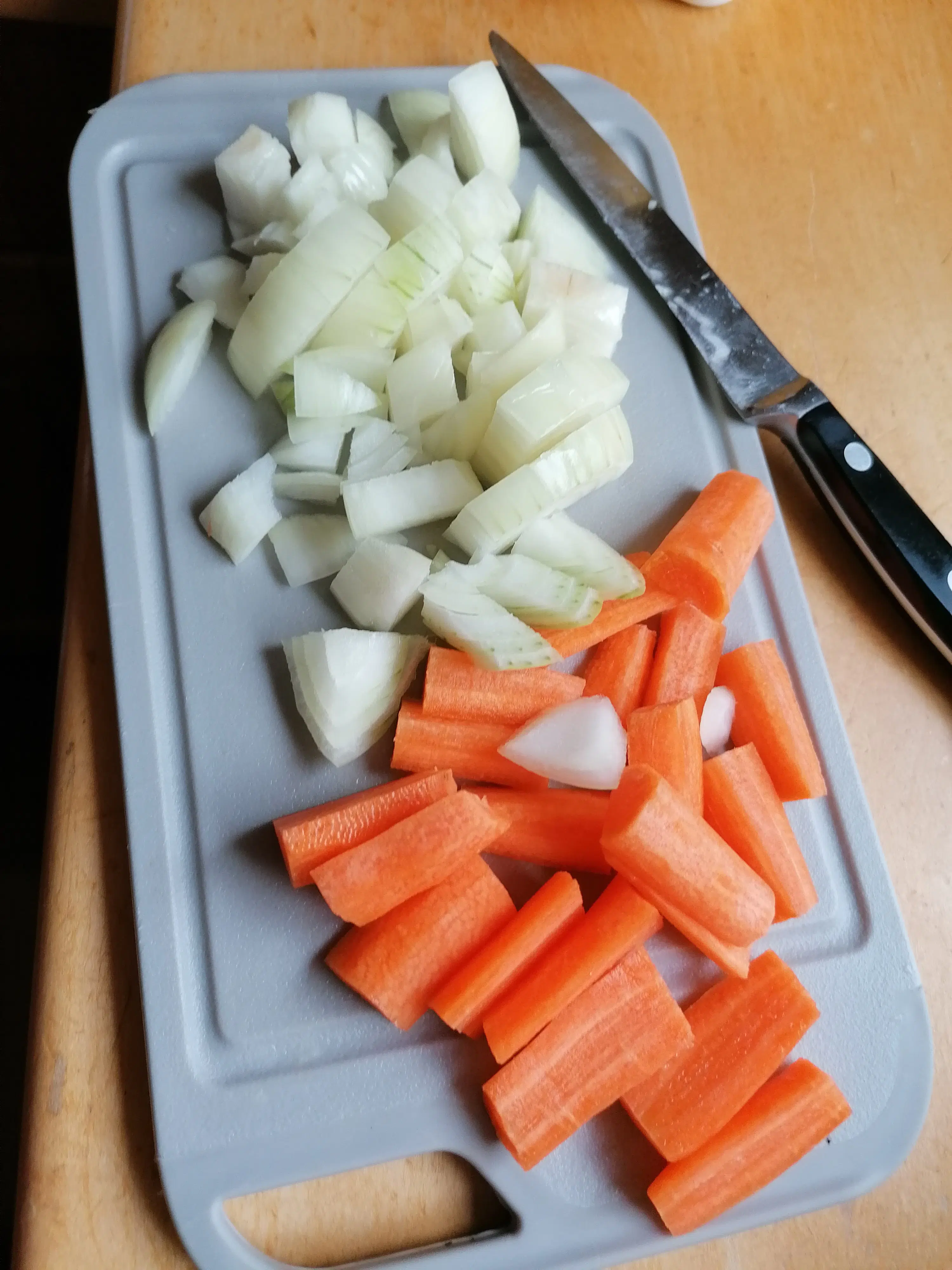 Zwiebel schälen und fein hacken. Karotten auch schälen und in längliche Spalten schneiden. 