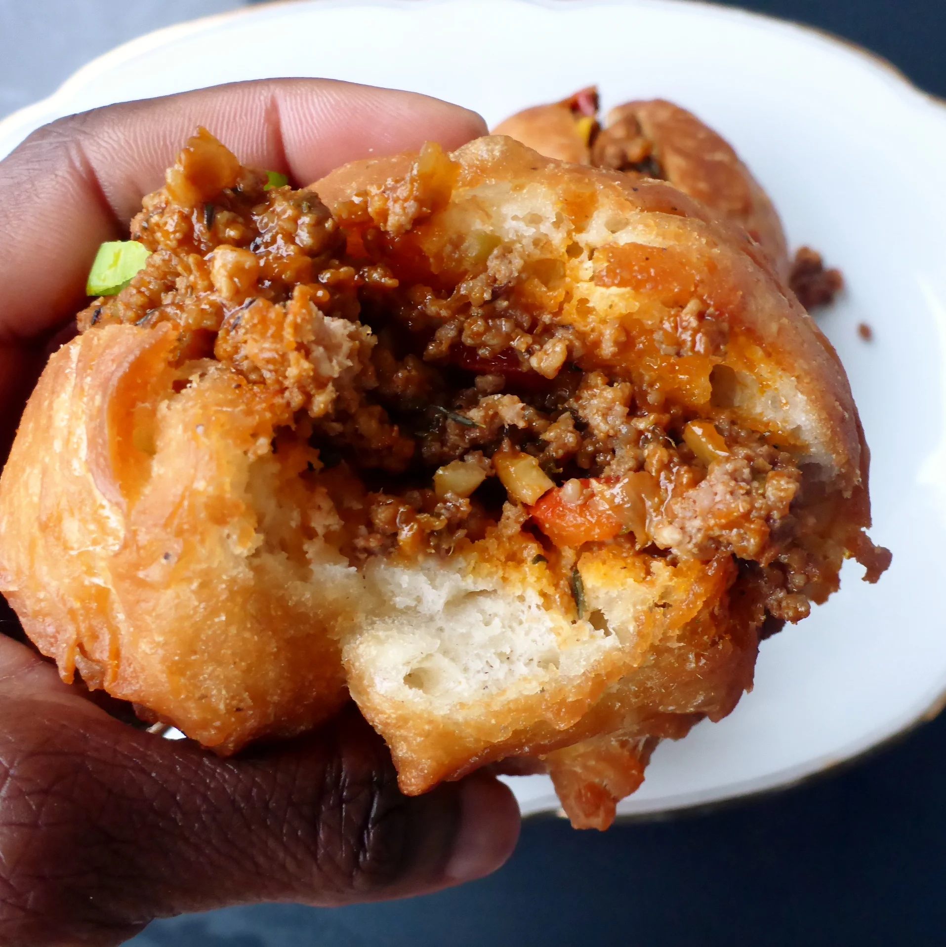 Köstliche afrikanische frittierte Hefe Teigbällchen, gefüllt mit noch warm frisch zubereiteter Hackfleischsauce.