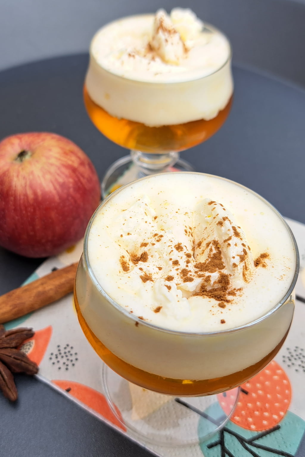 Apple liqueur in a beautiful liqueur glass topped with freshly whipped cream and sprinkled/ dusted with cinnamon. 
