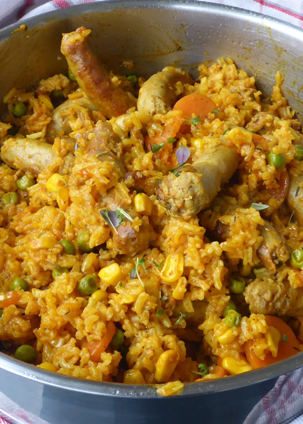 Frisch gekochte Reis mit Bratwürsten und Gemüse in der Pfanne. 