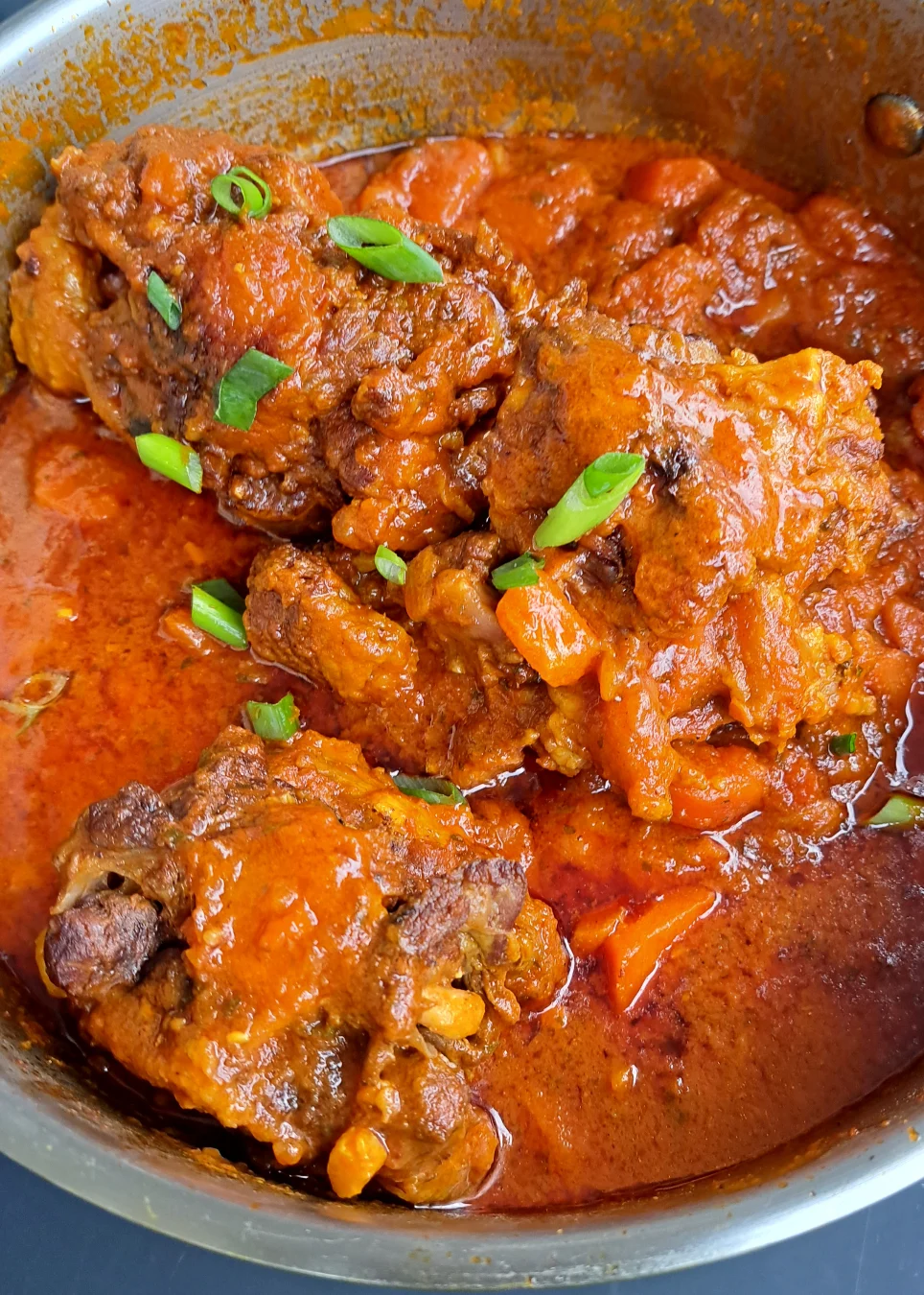 African  oxtail stew after 3.25 hours of cooking garnished with spring onion.