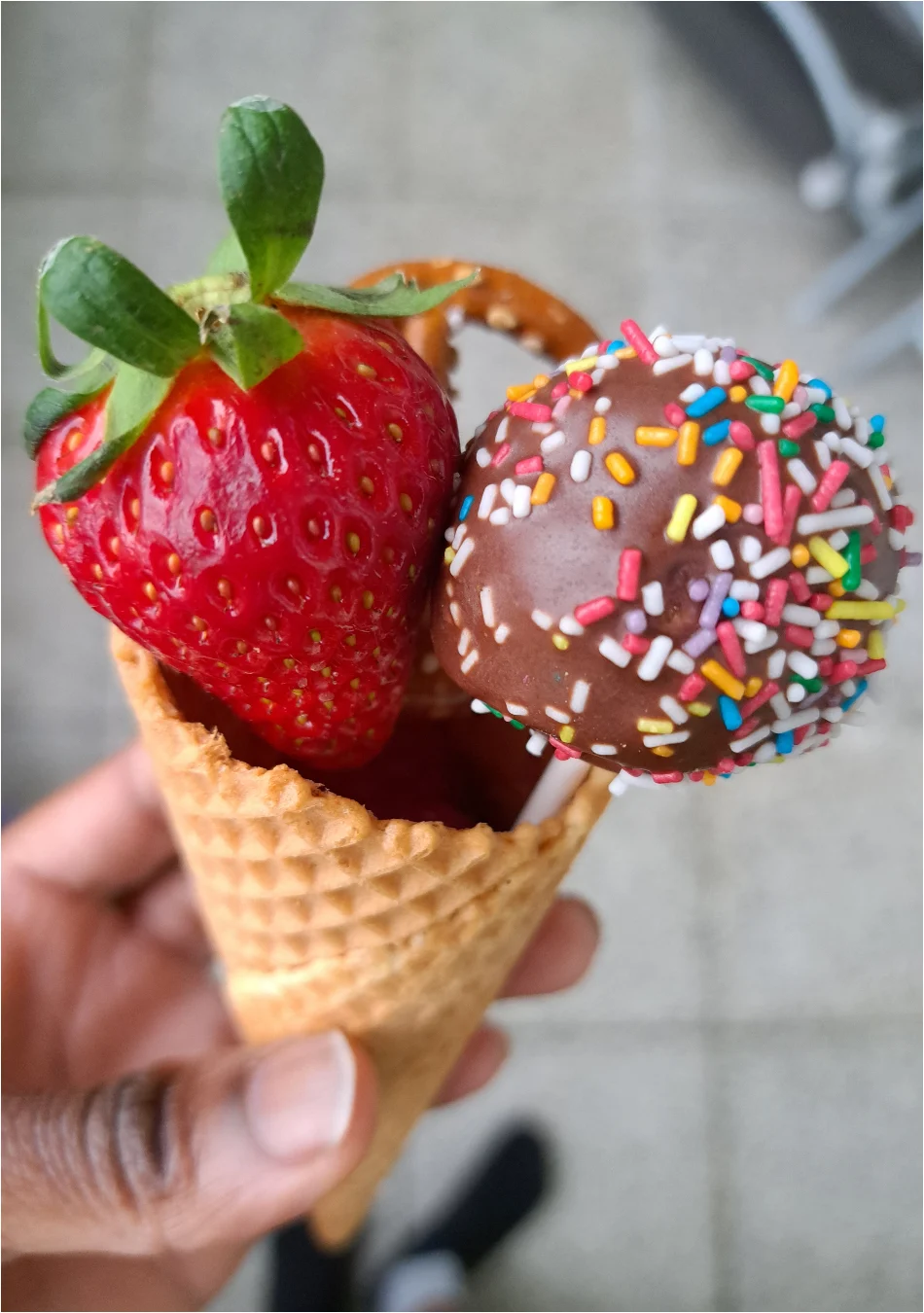 Eistüte, gefüllt mit leckeren Köstlichkeiten wie Erdbeeren, Himbeeren, Blaubeeren, selbstgemachten Cake Pops und Mini-Salzbrezeln als sinnvolle Mitgebsel Kindergeburtstag. 