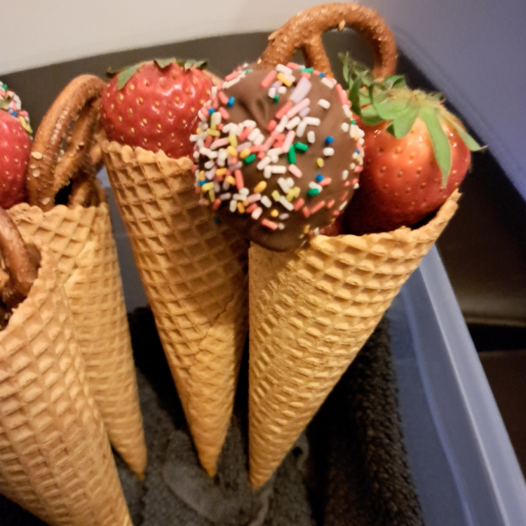 Eistüte, gefüllt mit leckeren Köstlichkeiten wie Erdbeeren, Himbeeren, Blaubeeren, selbstgemachten Cake Pops und Mini-Salzbrezeln als sinnvolle Mitgebsel Kindergeburtstag.