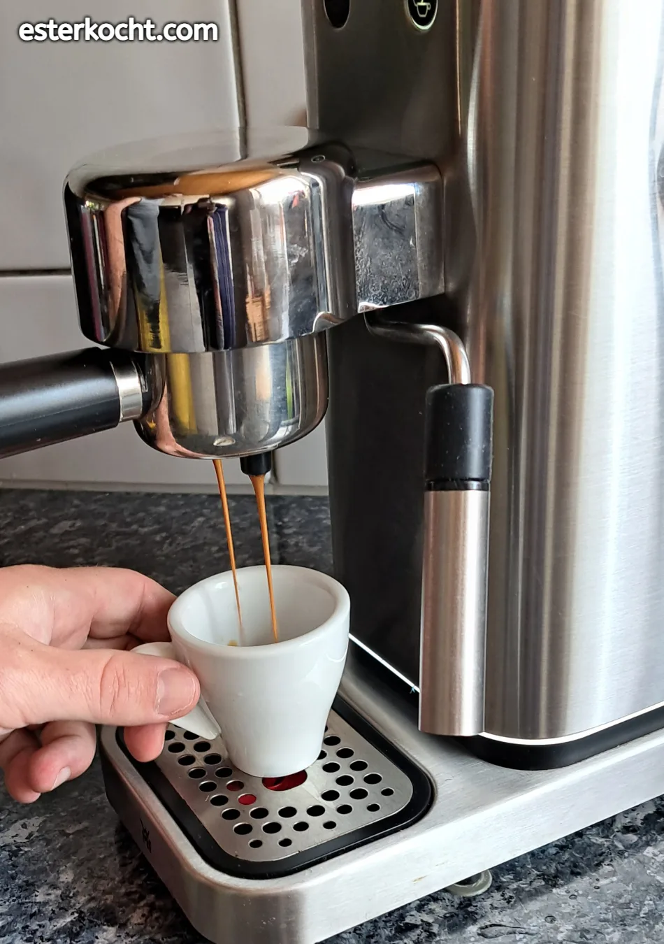 Ein Bild zeigt perfekten Espresso, der aus der Siebträgermaschine in die Tasse fließt, mit einem sanften, mäuseschwanzähnlichen Strahl.