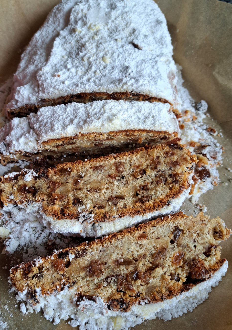 A beautifully presented German Stollen, generously dusted with powdered sugar, perfect for a festive Christmas treat.
