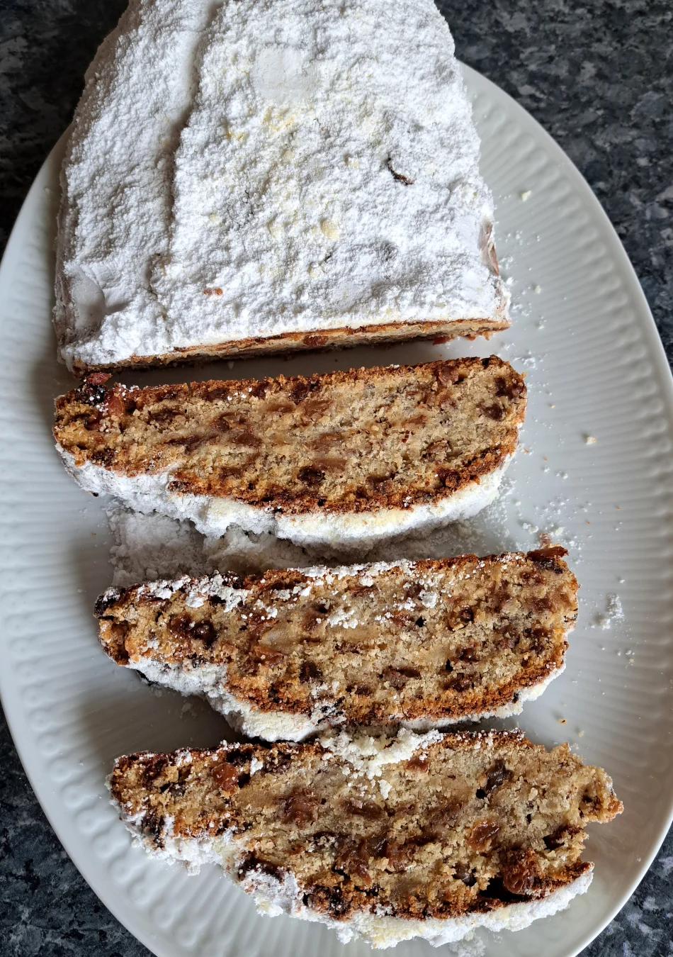 A beautifully presented Quark Stollen, generously dusted with powdered sugar, perfect for a festive Christmas treat.