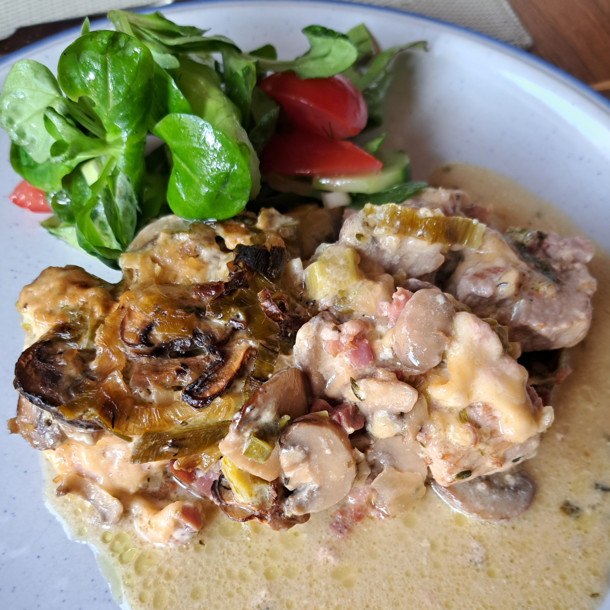 Lendchenpfanne auf einem Teller serviert, begleitet von frischem Salat.
