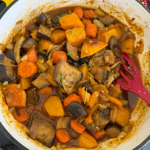 Frisch gekochter vegetarischer Eintopf aus Butternut-Kürbis, Auberginen und Zwiebeln garniert mit frischem Thymian. Gemüse Tajine. Gemüse Potjie