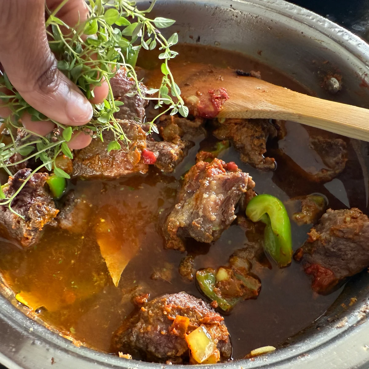 Gebräuntes Rindfleisch wird im Schmortopf mit Rotwein, Brühe und Thymian vermengt und langsam 60 Minuten geschmort – Schritt für namibisches geschmortes Rindfleisch.