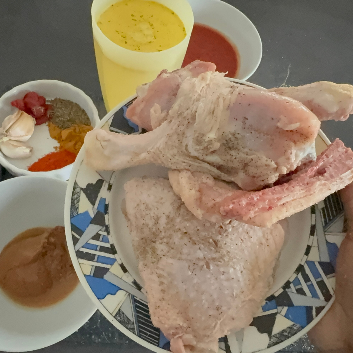 Rohe H&auml;hnchenschenkel werden mit Salz, Pfeffer und Cayennepfeffer f&uuml;r afrikanischen Erdnusseintopf gew&uuml;rzt.