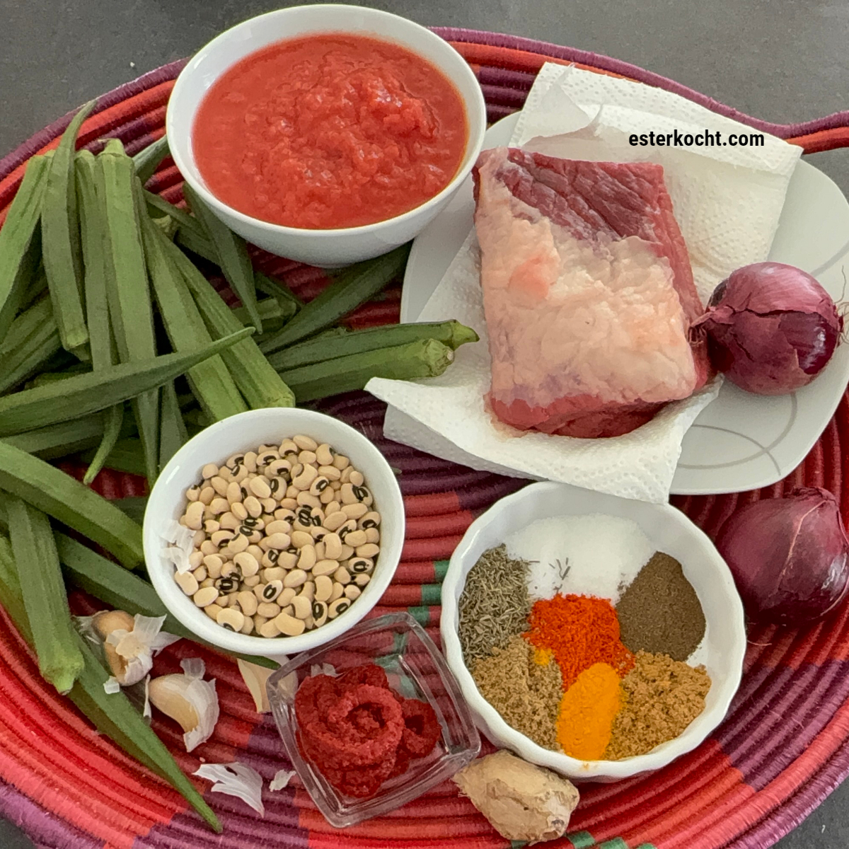 Zutaten und Gewürze für ein afrikanisches Schmorgericht mit Okra, Rindfleisch und schwarzaugigen Bohnen in einem Korb angerichtet