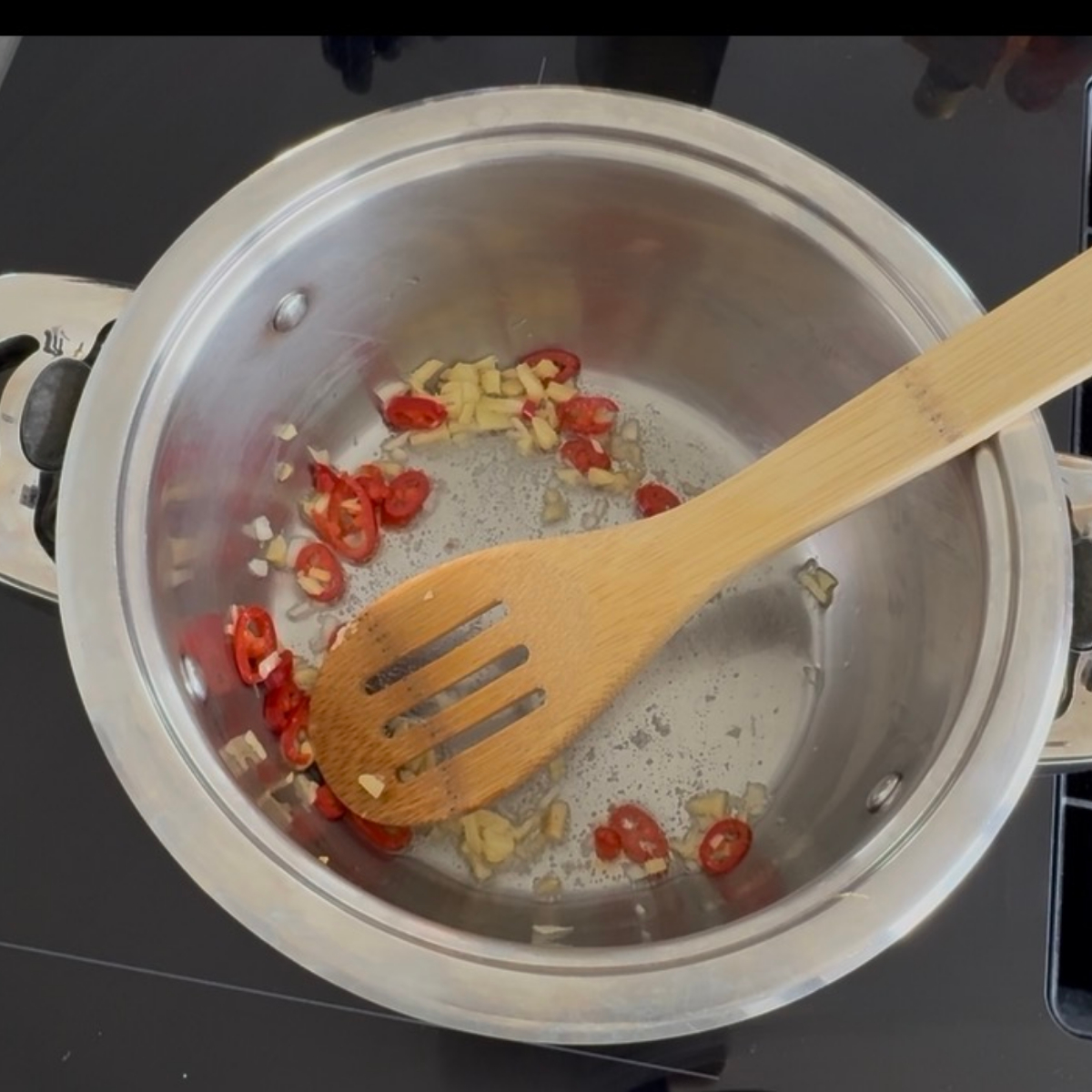 Ingwer, Knoblauch, Chili und Schwarzkümmel werden für das Mango-Chutney in Sonnenblumenöl angebraten.